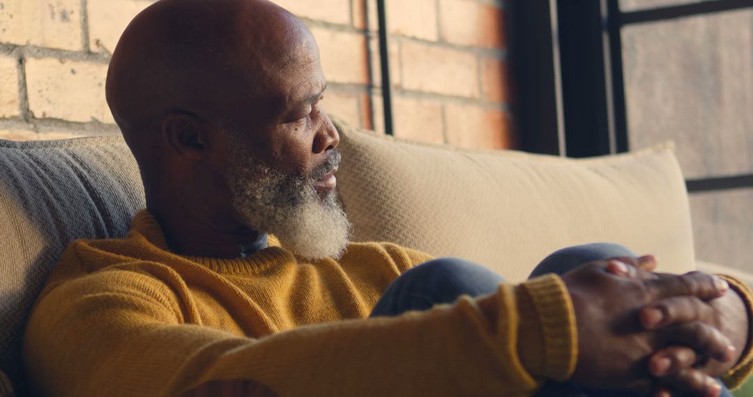 Pensive Older Man Sitting on Sofa Near Window - Free Images, Stock Photos and Pictures on Pikwizard.com