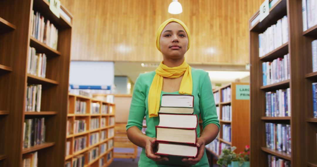 Young Woman Carrying Stack of Books in Library - Free Images, Stock Photos and Pictures on Pikwizard.com