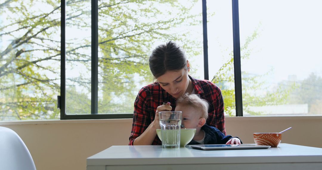 Mother Feeding Baby at Bright Breakfast Table - Free Images, Stock Photos and Pictures on Pikwizard.com