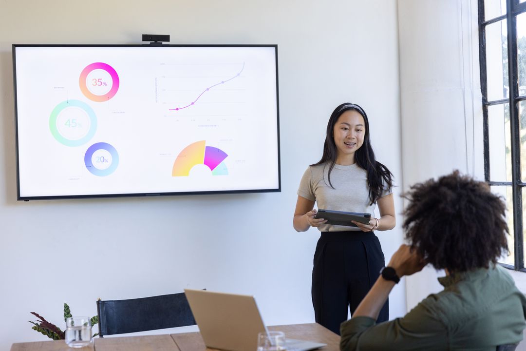 Colleagues Presenting Data and Collaborating in Modern Office