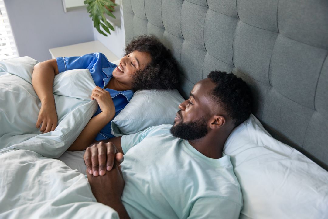Smiling Couple Relaxing in Comfortable Bedroom Setting