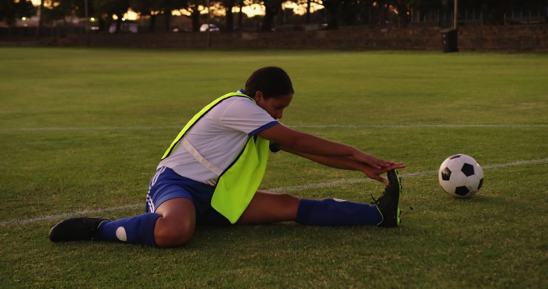 Biracial female football player stretching on field, unaltered with copy space - Free Images, Stock Photos and Pictures on Pikwizard.com