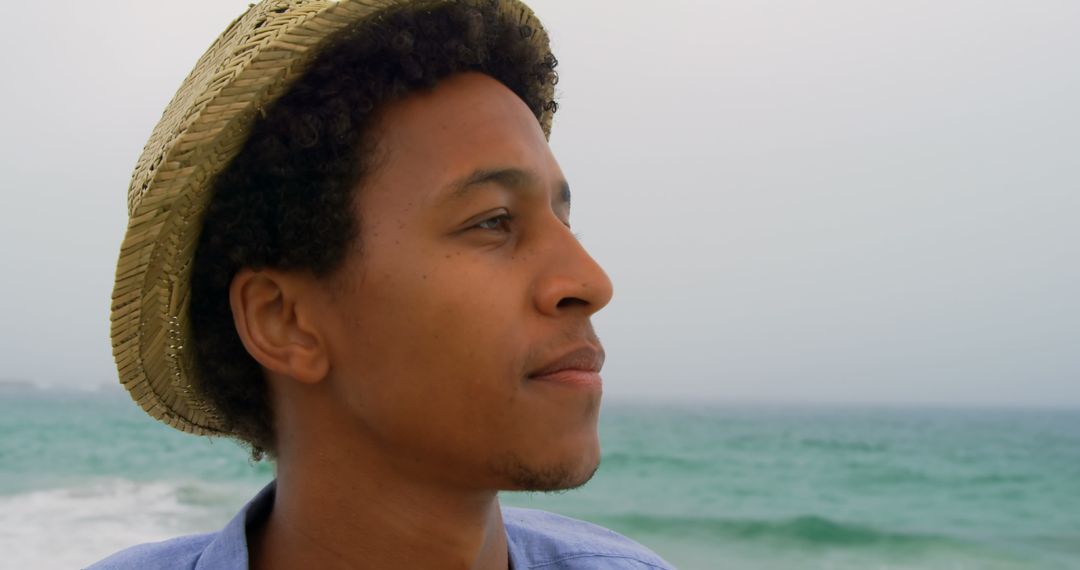 Man Wearing Straw Hat Enjoying Tranquil Beach View