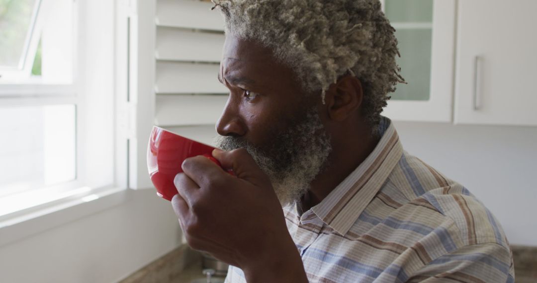 Mature African American Man Drinking Coffee by Kitchen Window - Free Images, Stock Photos and Pictures on Pikwizard.com