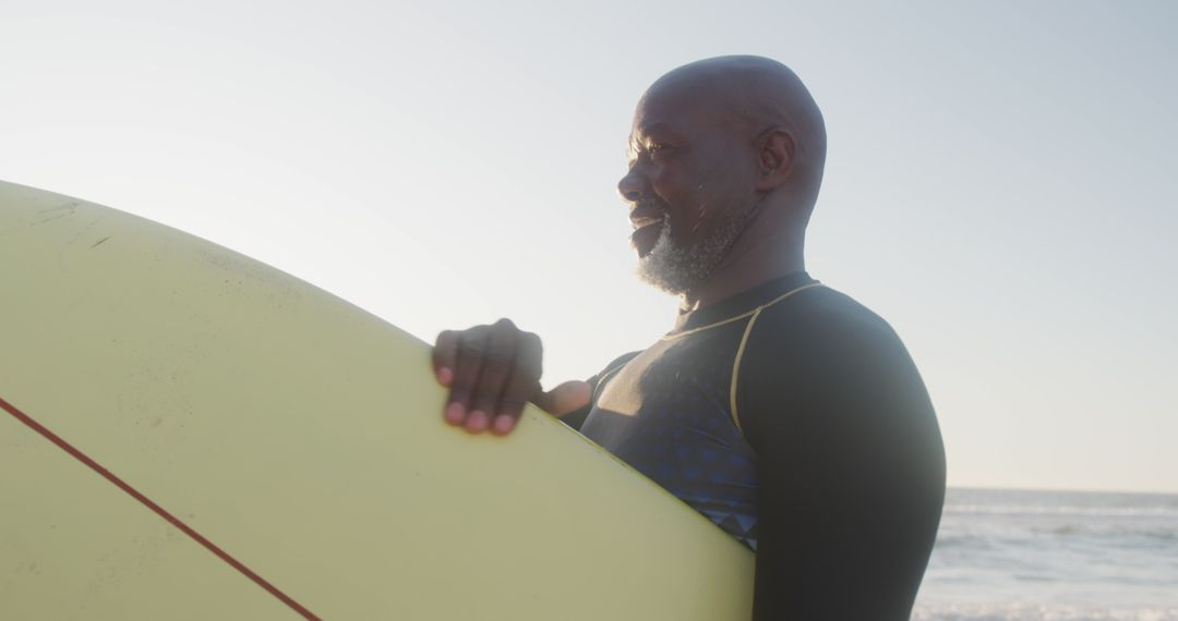 Smiling Elderly Man with Surfboard at Beach - Free Images, Stock Photos and Pictures on Pikwizard.com