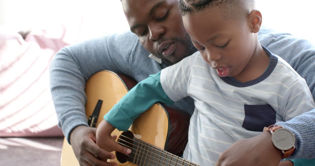 African American Father and Son Playing Guitar at Home, Bonding Time, Domestic Happiness - Free Images, Stock Photos and Pictures on Pikwizard.com