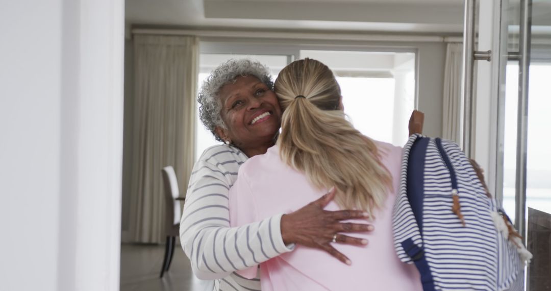 Elderly Woman and Young Woman Hugging Near Doorway in Bright Home - Free Images, Stock Photos and Pictures on Pikwizard.com