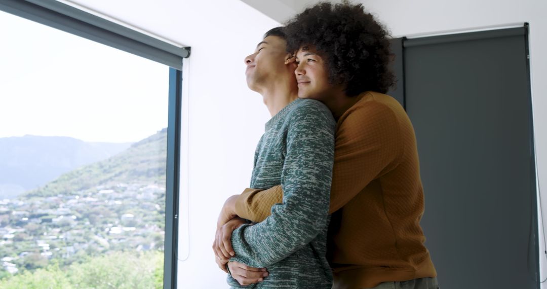 Affectionate Couple Embracing by Home Window with Scenic View