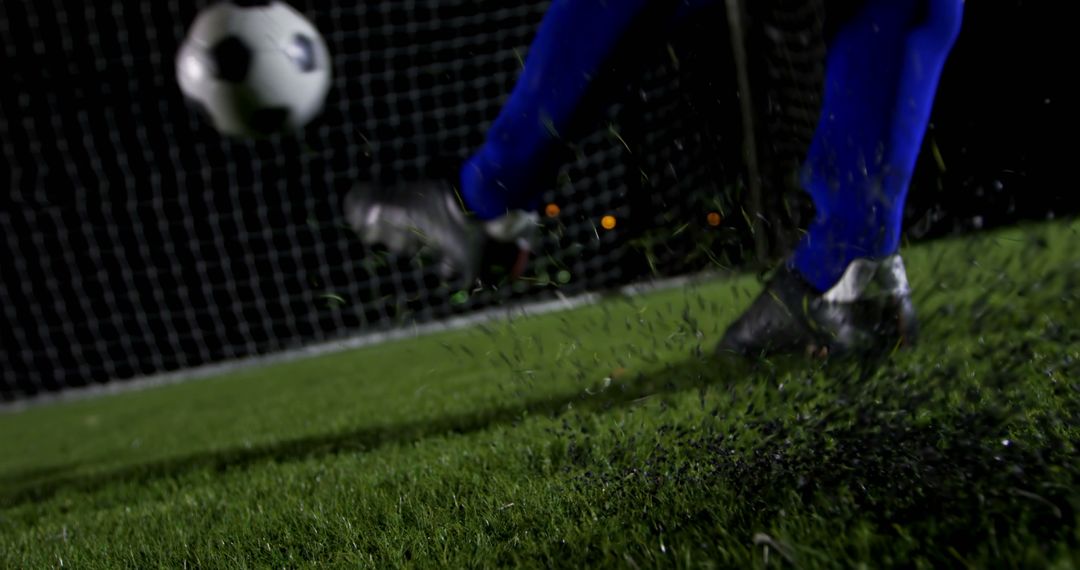 Close-up Soccer Player Kicking Ball Towards Goal Under Stadium Lights - Free Images, Stock Photos and Pictures on Pikwizard.com