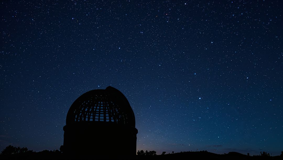 Observatory Dome Silhouette Under Starry Night Sky with Open Dome and Rural Horizon