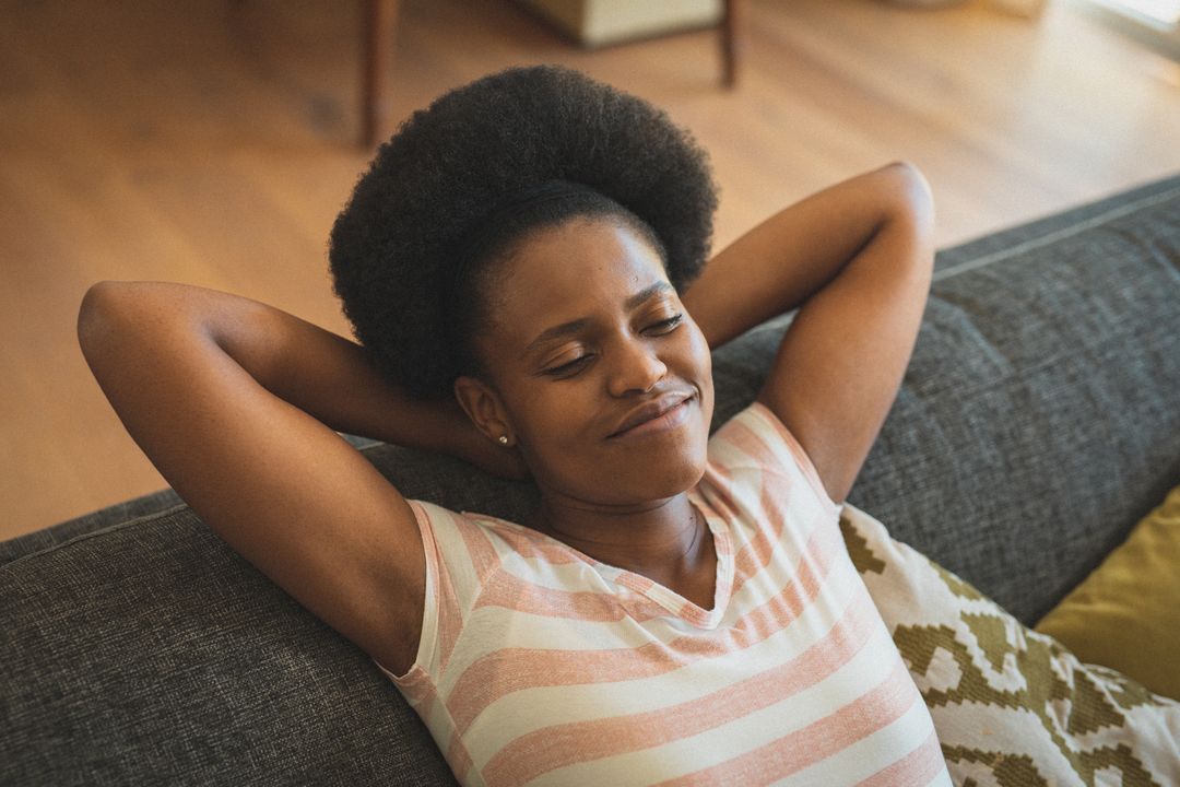 African American Woman Relaxing on Sofa with Eyes Closed - Free Images, Stock Photos and Pictures on Pikwizard.com