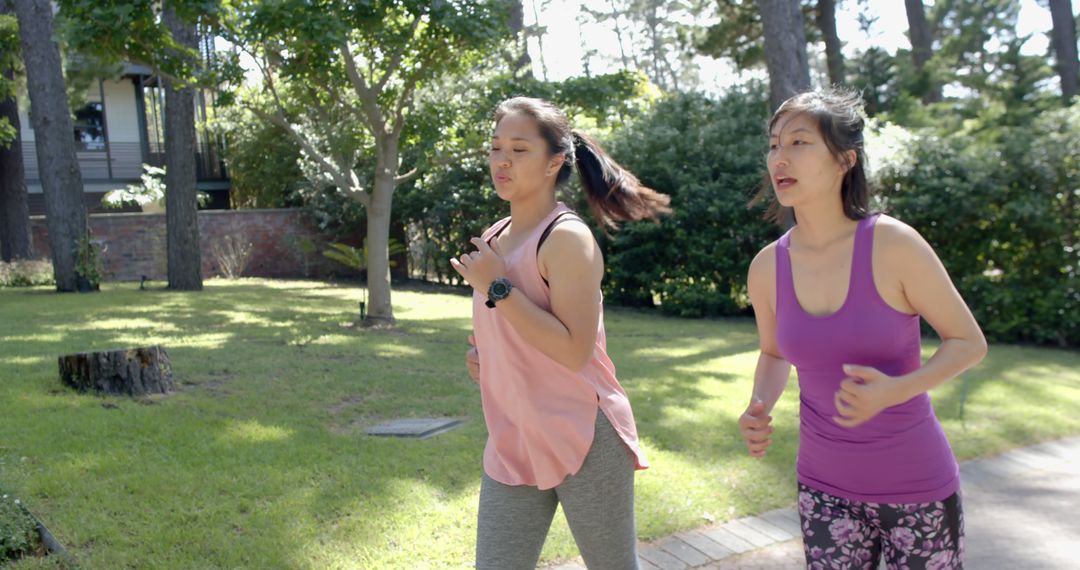 Two Women Jogging in Park on Sunny Day - Free Images, Stock Photos and Pictures on Pikwizard.com