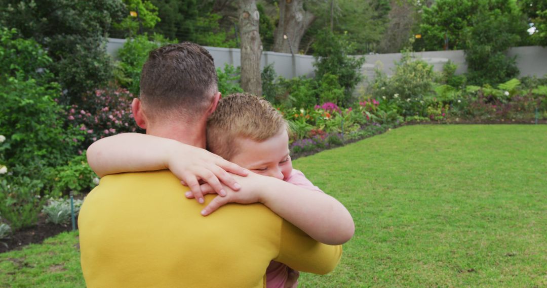 Father Embracing Son in Lush Garden Setting - Free Images, Stock Photos and Pictures on Pikwizard.com