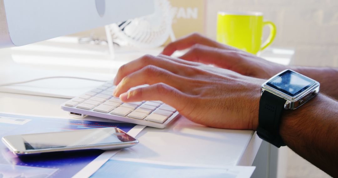 Person Typing on Keyboard in Modern Office with Smartphone and Smartwatch - Free Images, Stock Photos and Pictures on Pikwizard.com