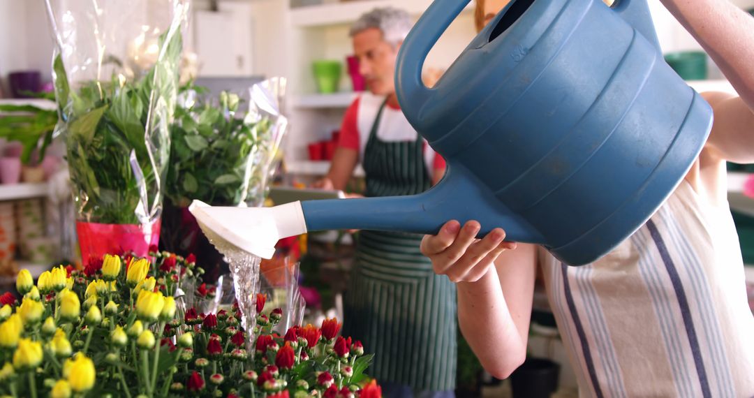 Florist Watering Plants in Store with Large Watering Can - Free Images, Stock Photos and Pictures on Pikwizard.com