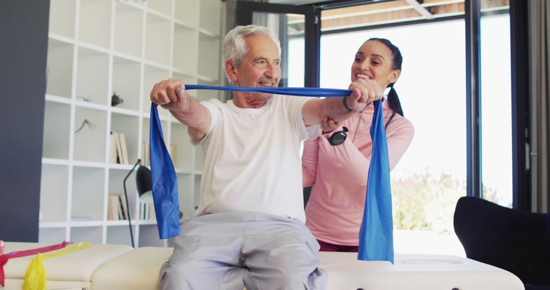 Senior man exercising with resistance band guided by physiotherapist - Free Images, Stock Photos and Pictures on Pikwizard.com