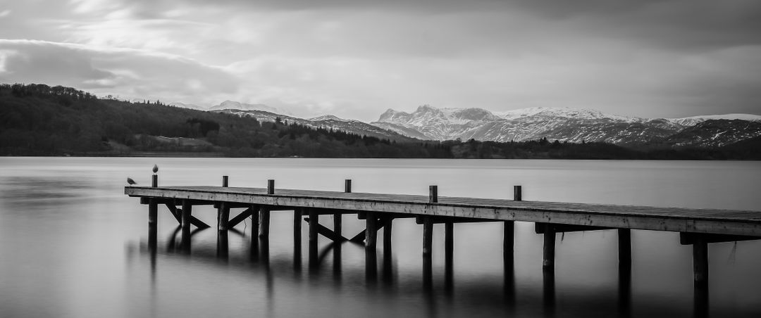 Tranquil Lake with Wooden Pier and Snow-Capped Mountains - Free Images, Stock Photos and Pictures on Pikwizard.com