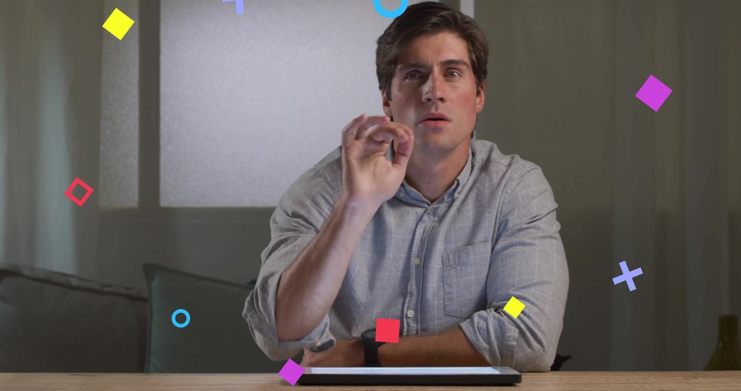Man Engaging with Tablet Surrounded by Vibrant Geometric Graphics