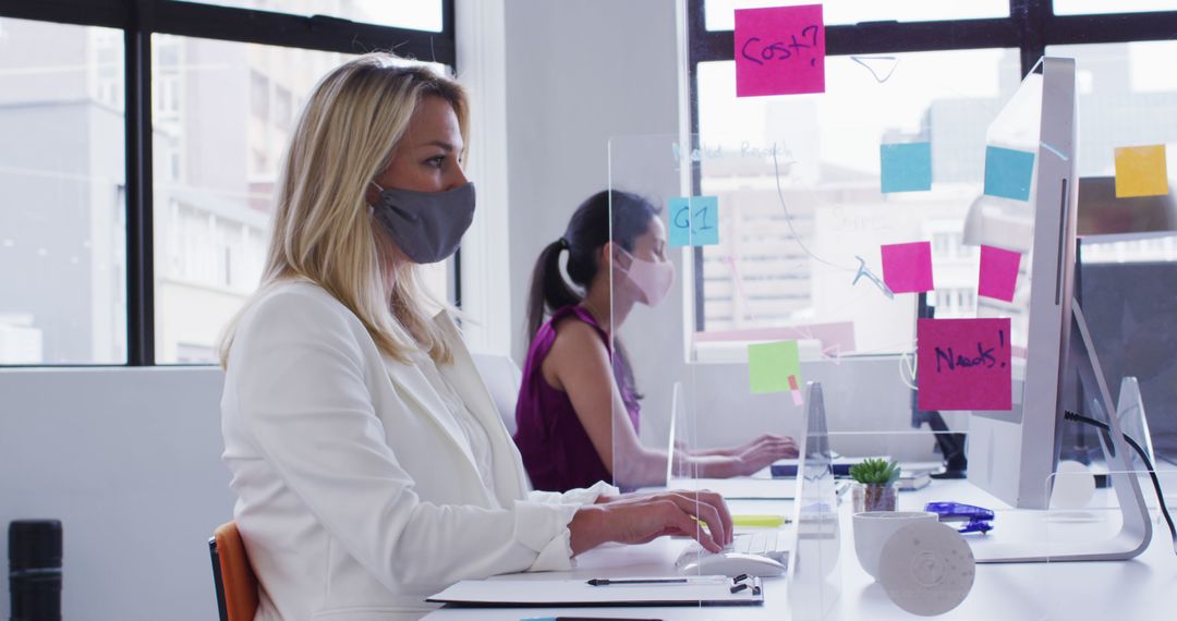 Businesswomen Wearing Masks Working in Modern Office - Free Images, Stock Photos and Pictures on Pikwizard.com