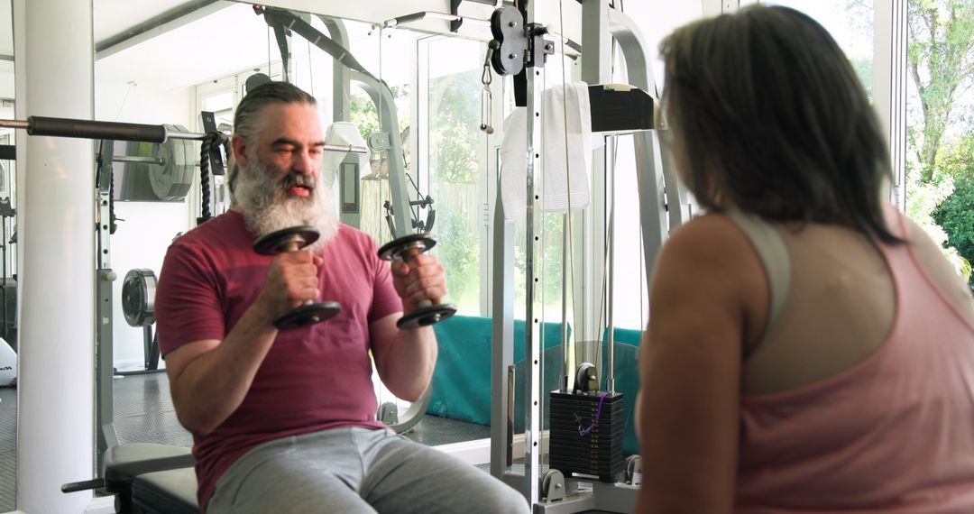 Senior Couple Exercising with Dumbbells in Modern Gym Setting