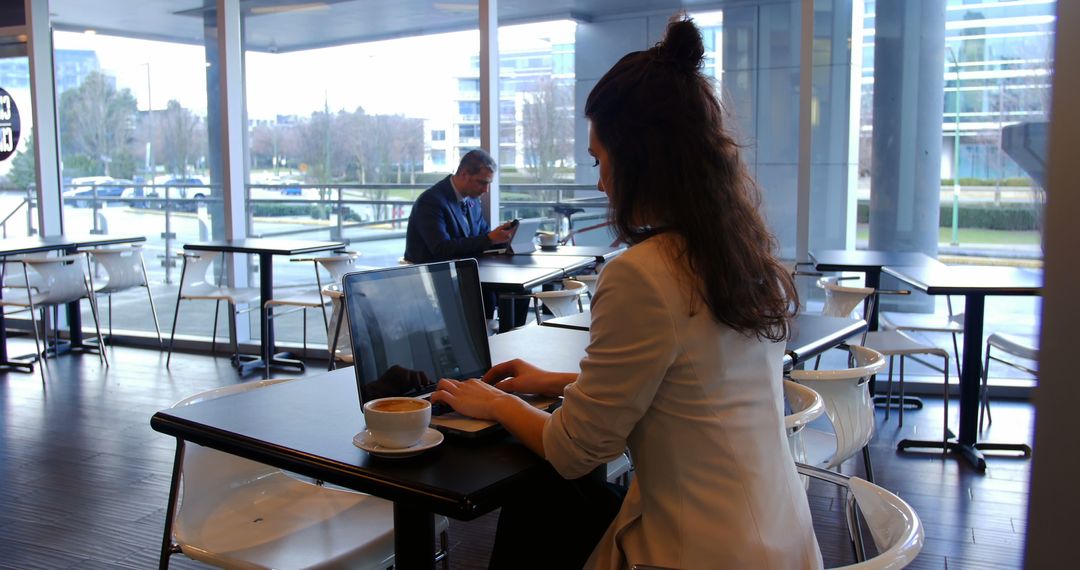 Businesswoman Working on Laptop in Modern Cafe - Free Images, Stock Photos and Pictures on Pikwizard.com