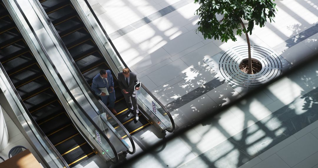 Business Professionals on Escalator in Modern Office - Free Images, Stock Photos and Pictures on Pikwizard.com