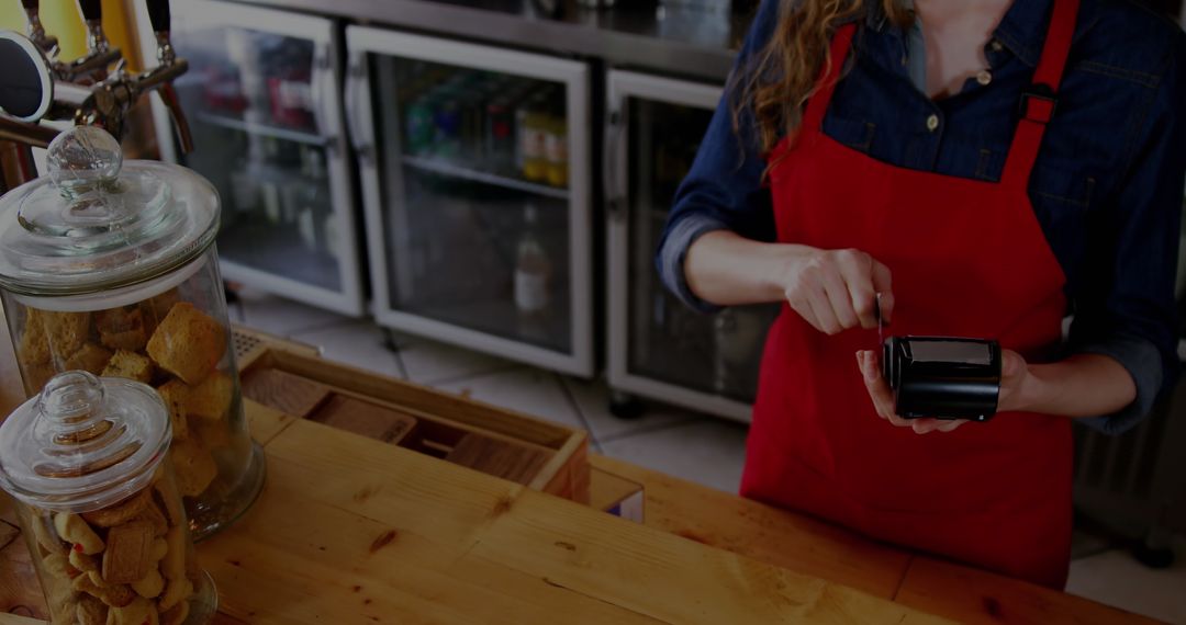 Coffee Shop Employee Processing Payment at Counter