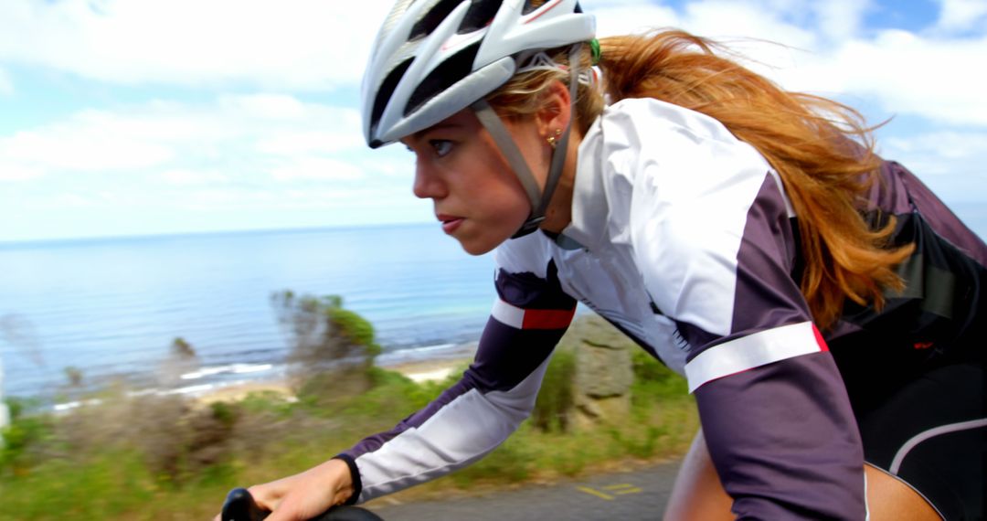 Focused Female Cyclist on Coastal Road Ride - Free Images, Stock Photos and Pictures on Pikwizard.com