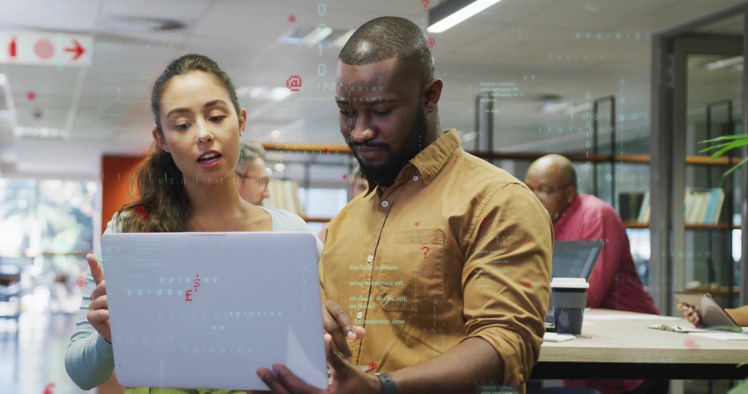 Coworkers Collaborating Over Laptop in Modern Open-Plan Office Environment