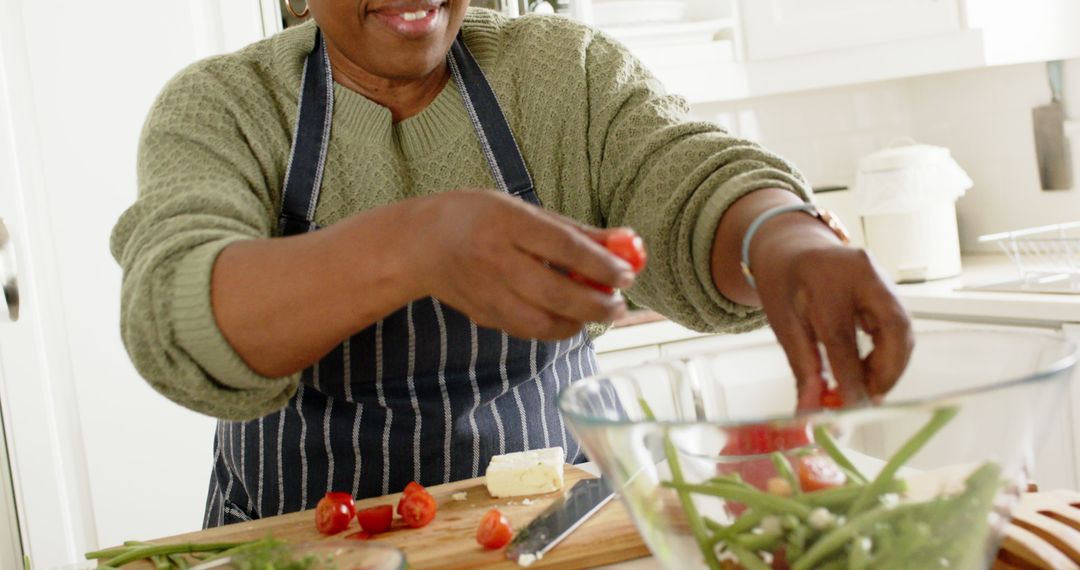 Senior woman preparing fresh salad in modern home kitchen - Free Images, Stock Photos and Pictures on Pikwizard.com