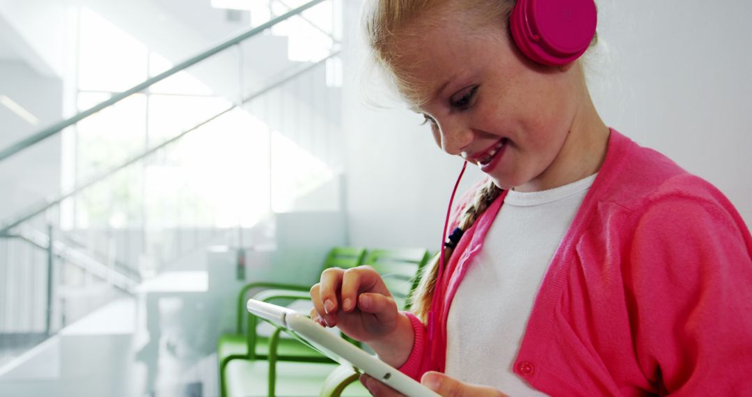 Young girl using digital tablet with headphones, enjoying technology indoors - Free Images, Stock Photos and Pictures on Pikwizard.com