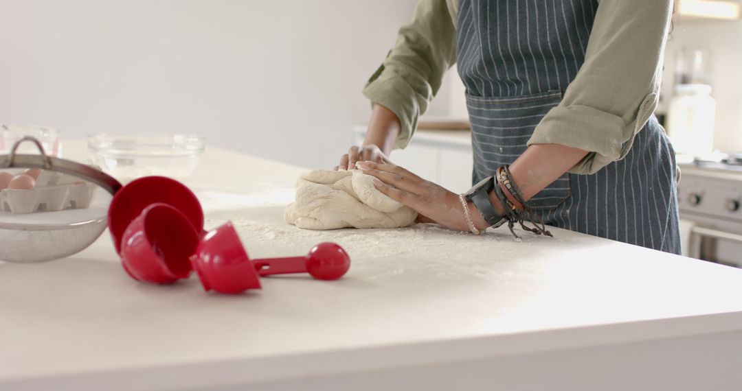Focused Baker Kneading Dough on White Surface