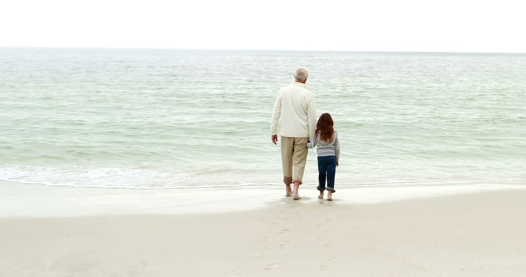 Grandfather and Granddaughter Walking on Beach Shore - Free Images, Stock Photos and Pictures on Pikwizard.com