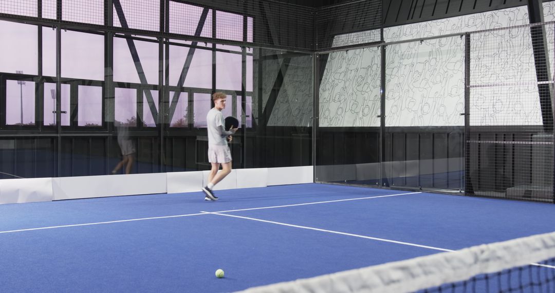 Man on Blue Padel Court with Racket and Net