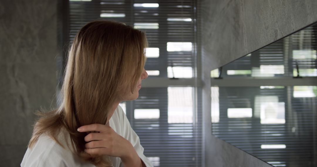 Woman Grooming Hair in Modern Bathroom - Free Images, Stock Photos and Pictures on Pikwizard.com