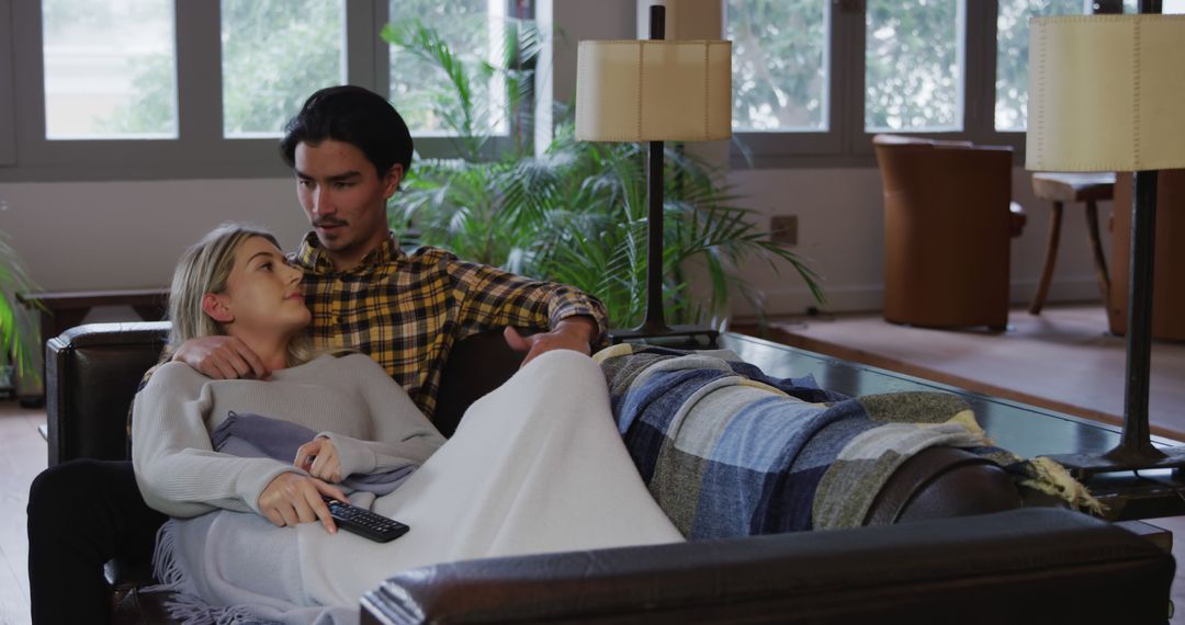 Couple Relaxing on Sofa Watching TV Indoors
