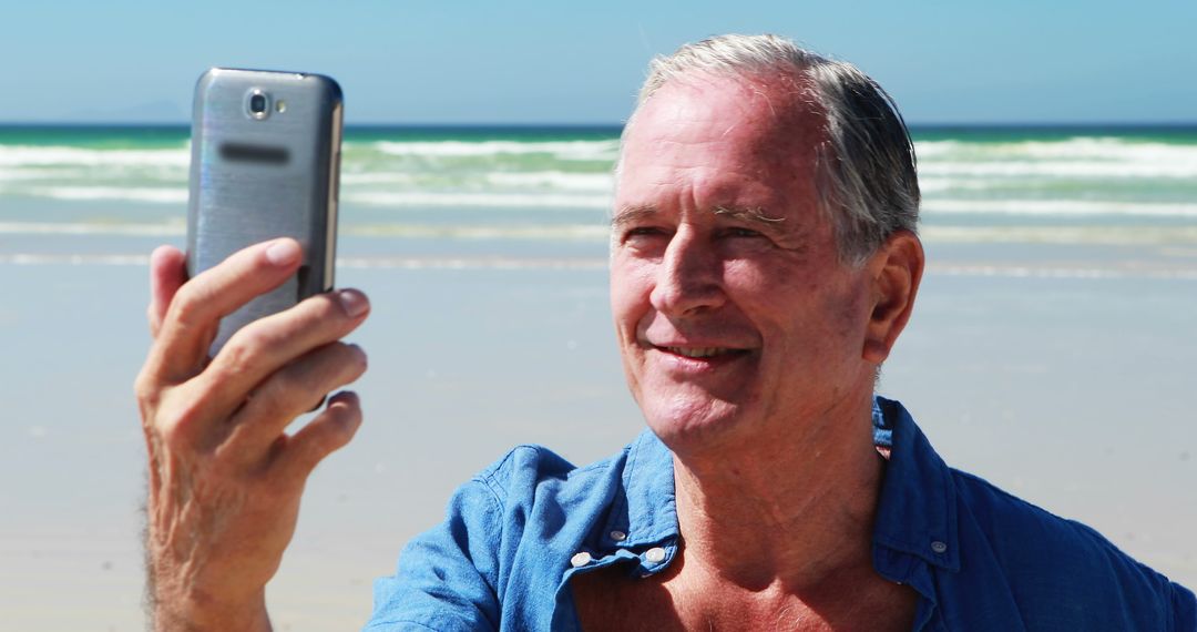 Smiling Senior Man Taking Selfie on Beach - Free Images, Stock Photos and Pictures on Pikwizard.com