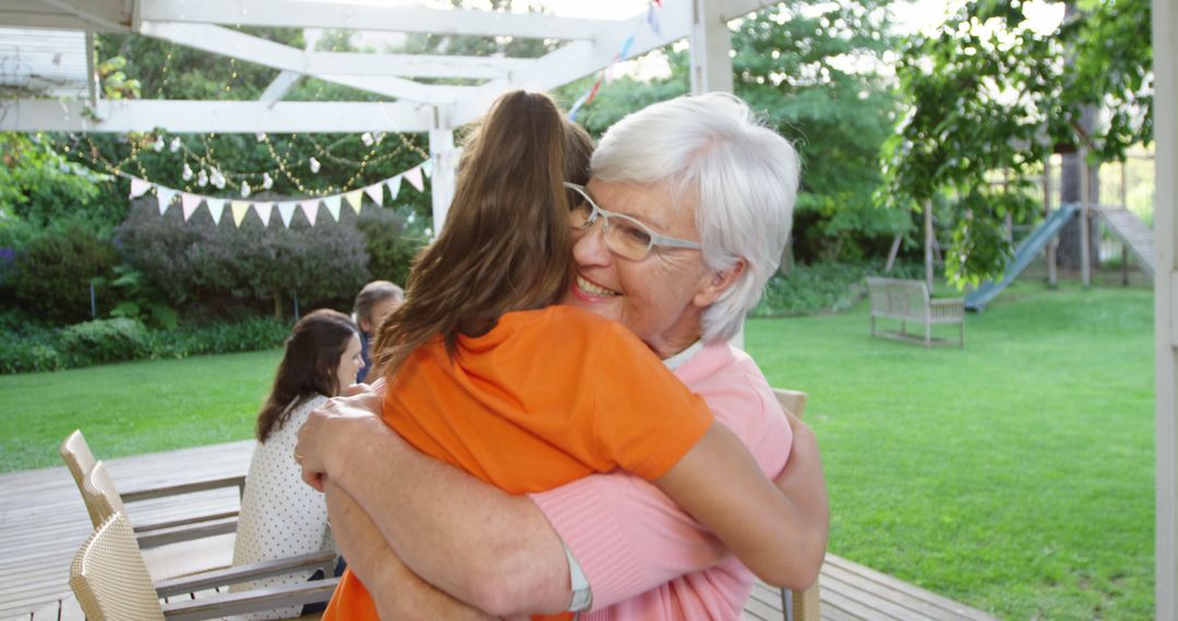 Grandmother Hugging Granddaughter during Family Reunion Outdoors - Free Images, Stock Photos and Pictures on Pikwizard.com