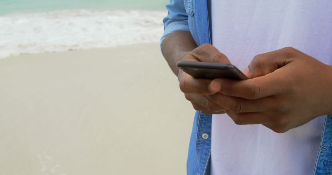Man Texting on Beach Relaxed Coastal Scenery