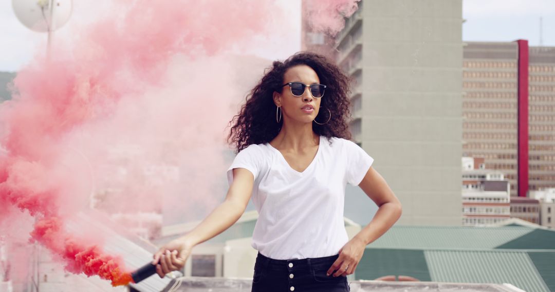 Confident Woman Holding Pink Smoke Bomb on Rooftop - Free Images, Stock Photos and Pictures on Pikwizard.com