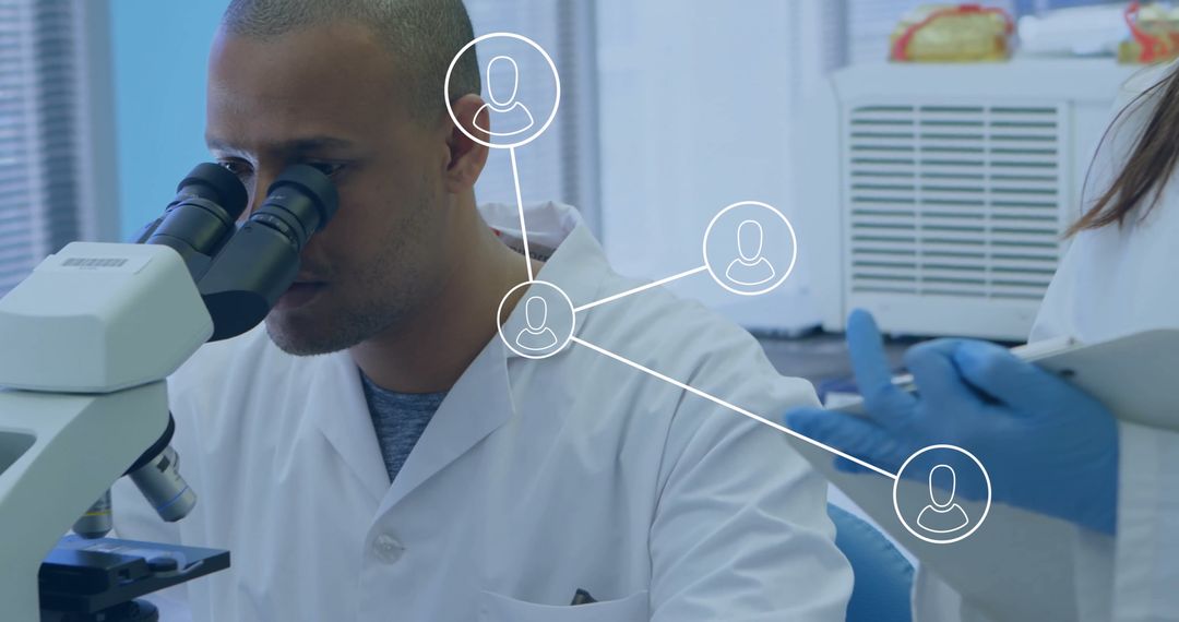 Scientist in Laboratory Coat Using Microscope, Highlighting Collaboration