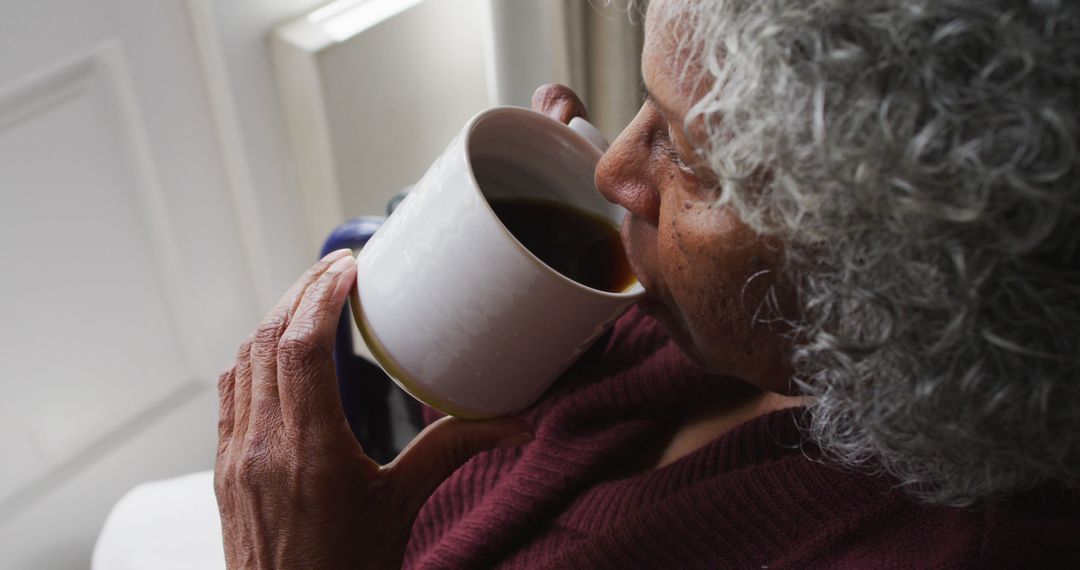 Elderly Woman Drinking Coffee Near Window - Free Images, Stock Photos and Pictures on Pikwizard.com