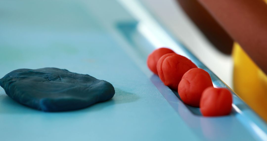 Close-up of modeling clay in varying shapes on blue surface - Free Images, Stock Photos and Pictures on Pikwizard.com