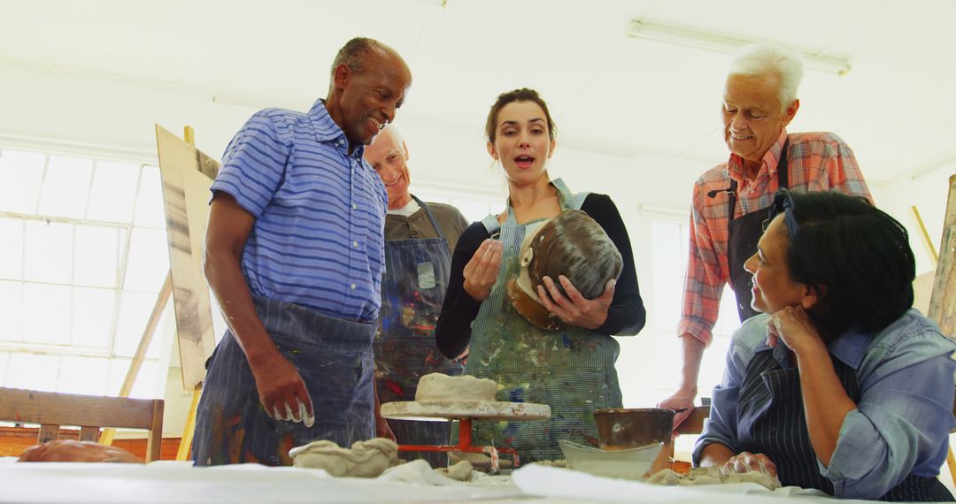 Adults Engaged in Pottery Class Learning Techniques Together