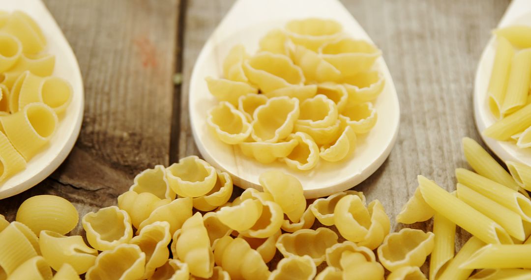 Assorted Uncooked Pasta Displayed on Wooden Table - Free Images, Stock Photos and Pictures on Pikwizard.com