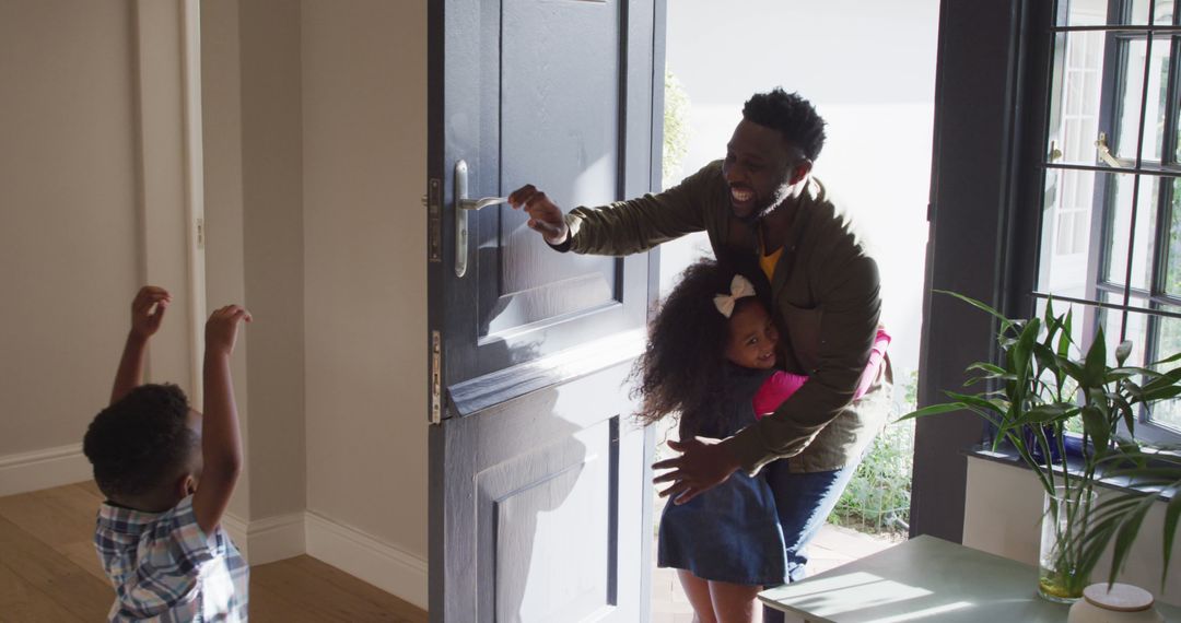 African American Father Arriving Home Hugging Daughter as Son Excitedly Welcomes - Free Images, Stock Photos and Pictures on Pikwizard.com