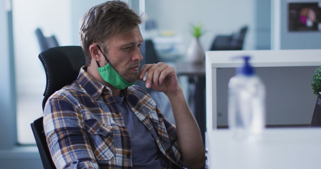 Man Contemplating at Office Desk with Mask Down During Pandemic - Free Images, Stock Photos and Pictures on Pikwizard.com