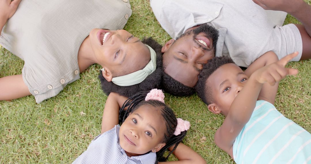 Happy African American Family Lying on Grass in Park - Free Images, Stock Photos and Pictures on Pikwizard.com