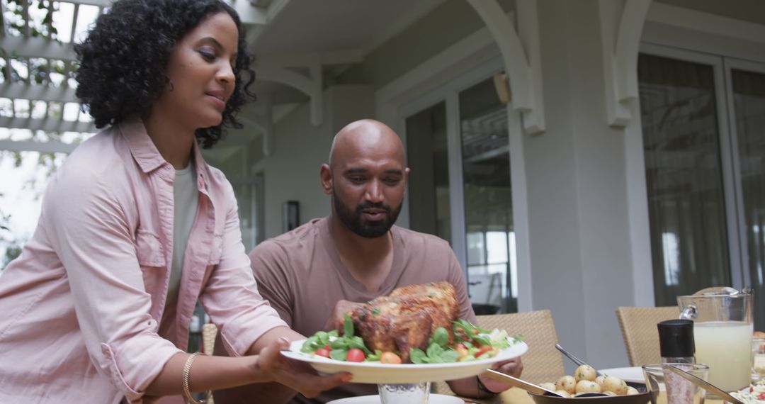 Multiracial Couple Enjoying Outdoor Family Dinner with Grilled Meat - Free Images, Stock Photos and Pictures on Pikwizard.com