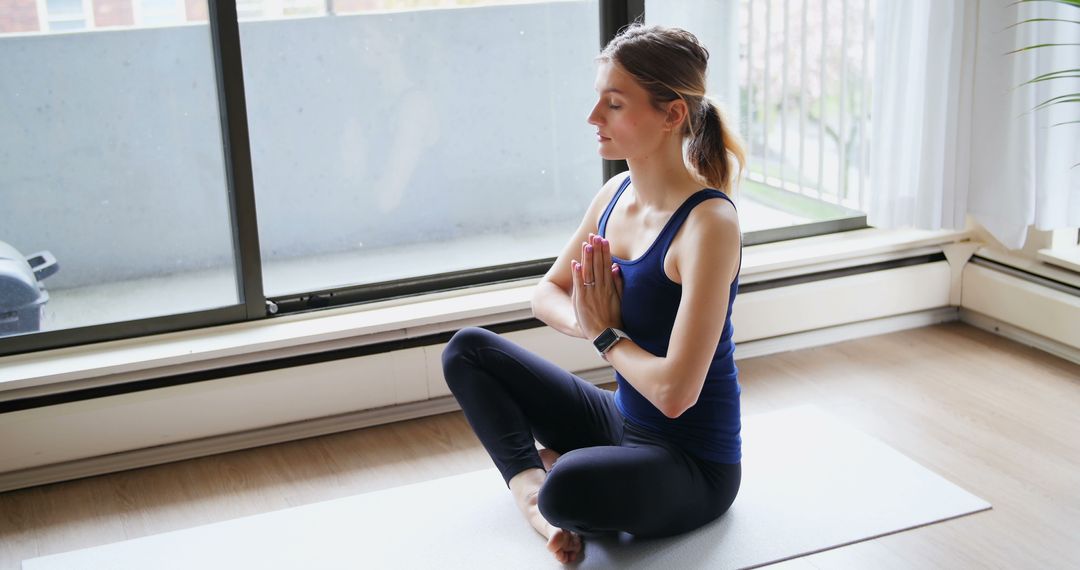 Young Woman Meditating at Home in Lotus Position - Free Images, Stock Photos and Pictures on Pikwizard.com